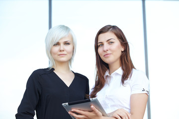 Obraz premium Two business woman with tablets