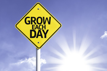 Grow Each Day road sign with sun background