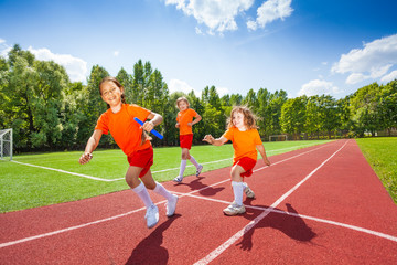 Obraz premium Three girls with one relay baton running