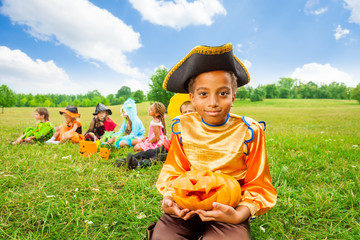 Smiling African boy in pirate costume and pumpkin
