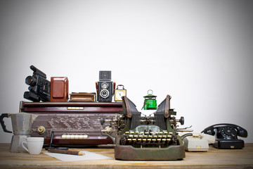 Vintage telephone, old typewriter, radio, lamp on table