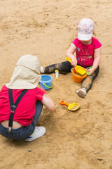 Two children are playing in the sand