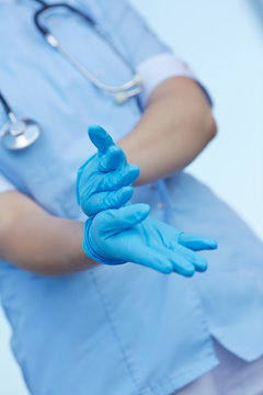 woman doctor wears medical gloves