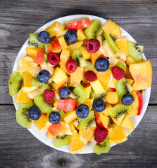 Top view of a fresh fruit salad with bananas kiwi orange blueber