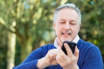 Obraz premium Mature man using a cell phone