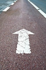 Arrow sign on asphalt surface