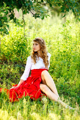 portrait of blonde woman sitting under the tree