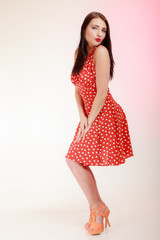 Fototapeta premium Full length pinup girl woman in retro red dress blowing a kiss