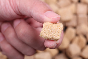 Brown cane sugar in the fingers