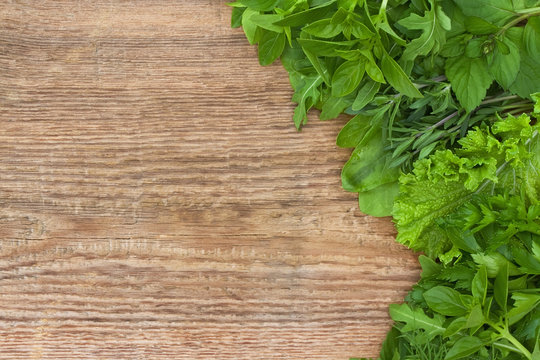 Fresh herbs on old wooden background