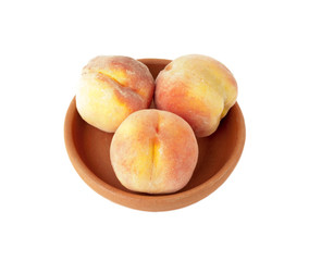 Three Ripe peaches in clay plate