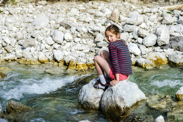 Teenage girl sitting on stone