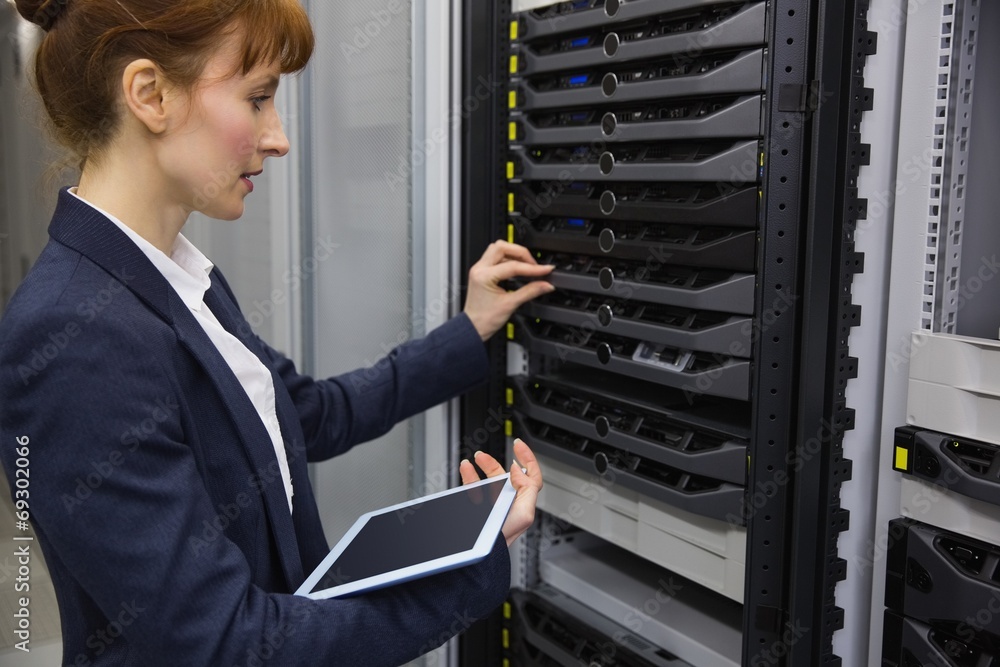 Aufkleber Pretty technician using tablet pc while working on servers