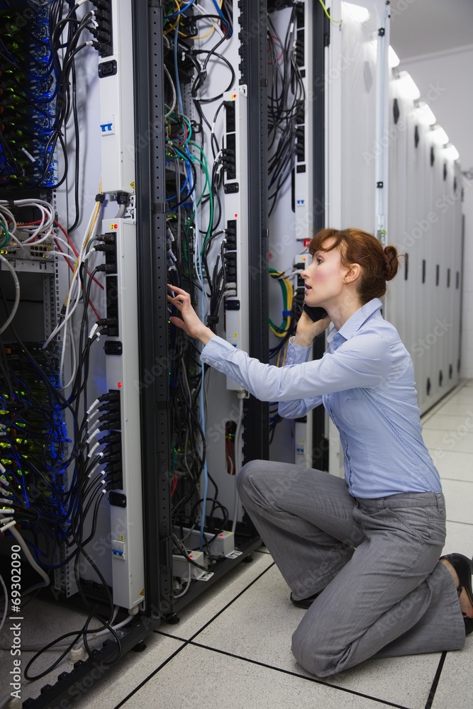 Aufkleber serious technician talking on phone while analysing server