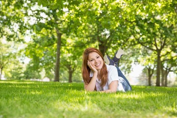 Naklejka na ściany i meble Pretty redhead relaxing in the park