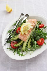 Portion steam salmon with a salad of arugula and fresh asparagus