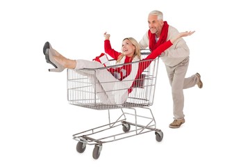 Festive couple messing about in shopping trolley