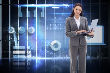Composite image of businesswoman smiling with a laptop