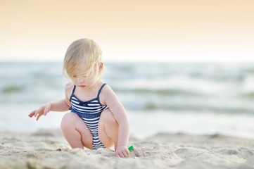 Adorable little girl having fun on a beach