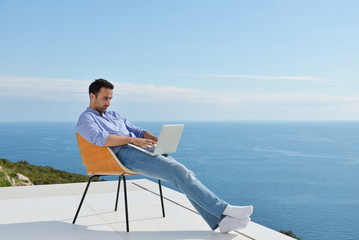 relaxed young man at home on balcony