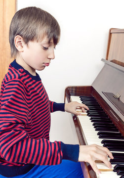 Cute funny little child playing piano