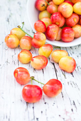 Pink cherries an old white board.