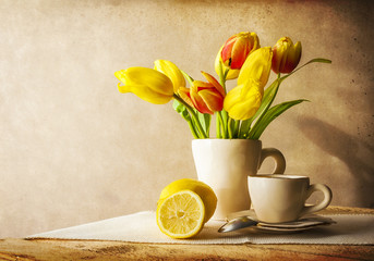Still life bouquet yellow tulips cup of tea