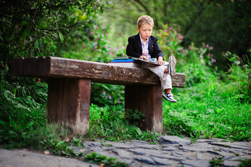 Fototapeta premium Little preschooler kid reading outdoor