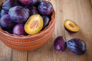 organic ripe plums in a clay bowl
