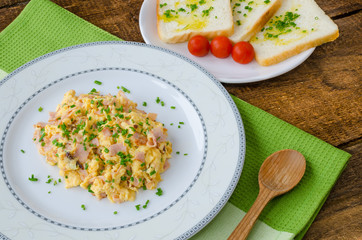 Scrambled eggs with chive and bacon, toast with herbs