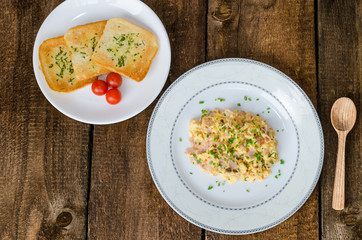 Scrambled eggs with chive and bacon, toast with herbs