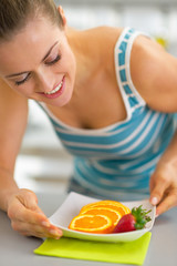 Obraz na płótnie Canvas Young woman making fruits plate