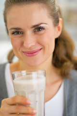 Portrait of happy young woman with glass of smoothie