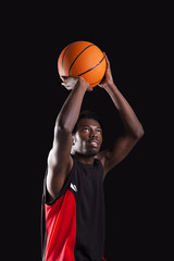 Basketball player dunking on black background
