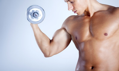 Fototapeta na wymiar Fitness man lifting weights on gray background
