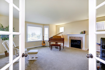 Room with fireplace, grand piano and guitar