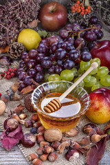 Naklejka na ściany i meble Autumn fruits, nuts and vegetables with honey on the table