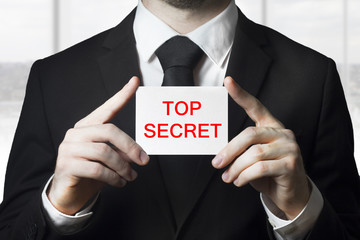 businessan holding sign top secret