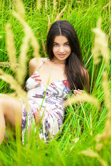 Young woman resting and day lying down on green grass