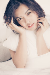 Fototapeta premium Portrait of a beautiful young woman in bed