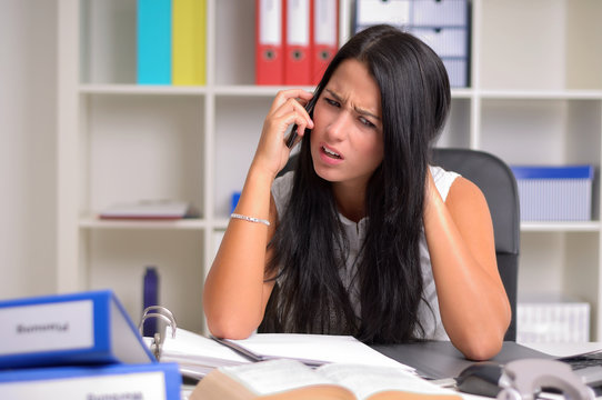 Ver&auml;rgerte junge Frau am Telefon