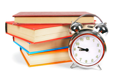 Naklejka premium Alarm clock and multi-coloured books.