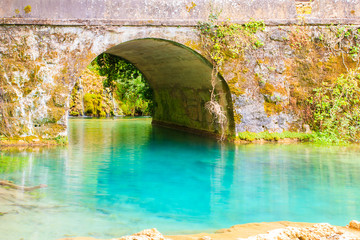 Turquoise river and old bridge