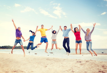 group of friends jumping on the beach