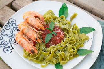 Spinach pasta with shrimps and tomato sauce