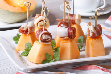 Italian appetizer: melon with ham on skewers horizontal
