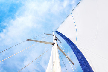 Sail and mast with sky in the background
