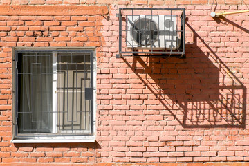 Window and air conditioner on a brick wall