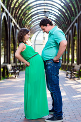 Happy pregnant couple playing romantic game