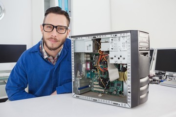 Fototapeta na wymiar Computer engineer smiling at camera beside open console